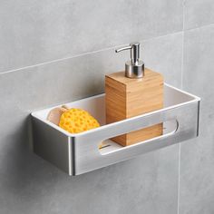 a soap dispenser and sponge in a stainless steel holder on the wall