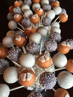 cake pops with white and orange frosting are arranged in a vase on a table