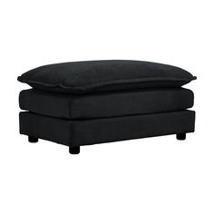 a black footstool sitting on top of a white floor next to a pillow