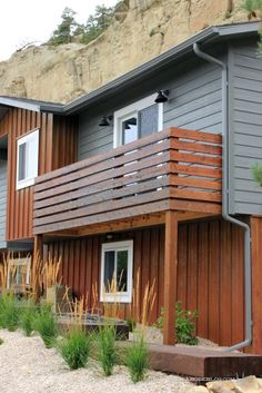 a house with wooden balconies next to a cliff