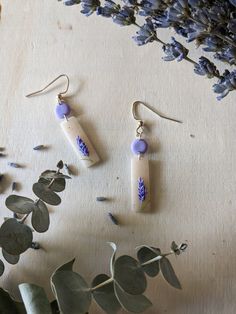 These hook earrings feature a beige granite rectangular design adorned with lavender accents, creating an elegant and versatile accessory for any occasion. Handmade Lavender Drop Earrings, Handmade Trendy Lavender Jewelry, Trendy Handmade Lavender Jewelry, Trendy Lavender Earrings For Gift, Handmade Adjustable Lavender Earrings, Beige Drop Earrings For Gift, Trendy Beige Earrings For Gift, Handmade Purple Earrings For Everyday, Handmade Minimalist Purple Earrings