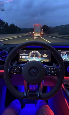 the interior of a car is lit up with blue lights and features steering wheel controls