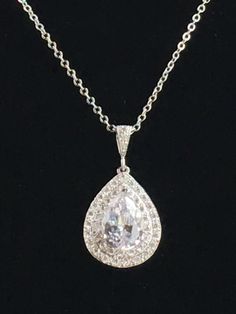 Beautiful! clear cubic zirconia bridal tear drop pendant and necklace in rhodium plated brass setting. Necklace pendant features a large teardrop with pear cut cubic zirconia center surrounded by two rows of tiny zirconia crystals which dangles from a cubic zirconia detailed bail. Length of the rhodium plated chain is 18 inches and comes with 2 inches extender and lobster clasp. For matching earrings click: https://www.etsy.com/listing/495791548/teardrop-crystal-earrings-bridal-cubic?ref=listing Dazzling White Gold Drop Necklace For Wedding, White Gold Drop Necklace With Diamond Accents For Wedding, Classic Teardrop Bridal Necklace With Diamond Accents, Diamond White Teardrop Pendant Drop Necklace For Formal Events, Diamond White Teardrop Pendant Drop Necklace For Formal Occasions, Formal Diamond White Teardrop Pendant Drop Necklace, Silver Cubic Zirconia Jewelry With Teardrop Crown, Brilliant Cut Diamond White Drop Necklace For Wedding, Bridal Teardrop Necklace With Brilliant Cut For Formal Events