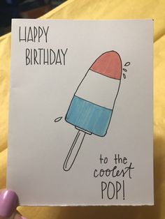 a hand holding up a birthday card with an ice cream cone on it and the words happy birthday to the coolest pop