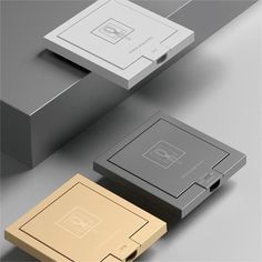 four different types of square and rectangle shaped objects on a gray surface, including one with an electronic device in the middle