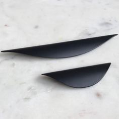 two black knives sitting on top of a white counter