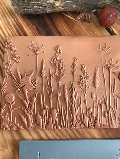 a chocolate mold that looks like flowers on a piece of wood with a knife next to it