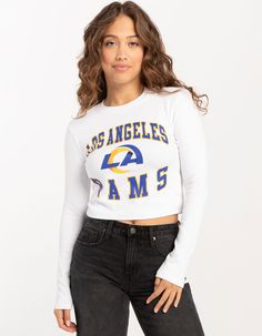 Nfl Los Angeles Rams Long Sleeve Baby Tee. Large Graphic Screened On Front. Ribbed Crew Neckline. Long Sleeves. Cropped Fit. 94% Cotton, 6% Spandex. Machine Wash. Imported.officially Licensed.model Is Wearing A Size Small Model Measurements:height: 5'7" Bust: 32"waist: 25"hips: 36" Fitted Tops For College, Sporty Tops For Spring, Sporty Stretch Tops With Text Print, Stretch Tops With Text Print For Spring, White Long Sleeve Crop Top With Graphic Print, Sporty Spring Top With Text Print, Spring College Tops With Text Print, Sporty Text Print Tops For Fall, Fitted Long Sleeve Top For College