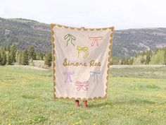 a sign that is in the grass with mountains in the background