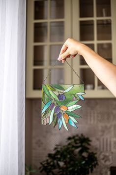 a hand is holding a paper hanging decoration