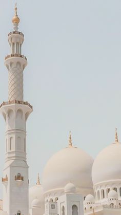 a large white building with a clock on it's side and a tower in the background