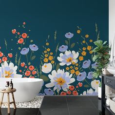 a bath tub sitting next to a wall with flowers painted on it's side