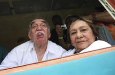 an older man sticking his tongue out while standing next to a woman in a car