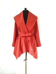 The jacket is made of a dark orange color crepe fabric (polyester and elasthanne). The jacket has an asymmetric cut (longer on the front), a big shawl collar, two pockets and a belt. Size: M (Fr size: 40) Length: Front: 90 cm - Back: 70 cm Composition: 97% Polyester - 3% Elasthanne Care of clothing: Dry cleaning only ! https://www.etsy.com/fr/shop/VLbasics?ref=seller-platform-mcnav Elegant Fitted Orange Outerwear, Formal Orange Outerwear For Fall, Orange Outerwear For Office In Fall, Chic Orange Blazer For Fall, Chic Orange Fall Blazer, Elegant Orange Office Outerwear, Asymmetrical Formal Outerwear For Fall, Asymmetrical Formal Fall Outerwear, Formal Asymmetrical Fall Outerwear