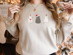 This Womens Cat Sweatshirt is a great way to tell everyone Meowy Christmas! The perfect Cat Sweatshirt for the Cat Lover in your life! One of our favorite Womens Christmas Shirt options.  Check out more Christmas Sweaters here: http://alturl.com/4swny *Gilden unisex heavy blend crewneck sweatshirt. Polyester and cotton.  *Unisex adult sizing.  *Props used in photo not included   SIZING  * Check out the sizing chart photo to see specific sizing for this item.  * Please note these are unisex sizes Crew Neck Top With Cat Design For Gift, Crew Neck Top With Cat Design As Gift, Christmas Sweaters Funny, Womens Christmas Shirts, Womens Christmas, Meowy Christmas, Christmas Tops, Cat Sweatshirt, Christmas Cat