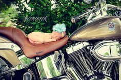 a baby is laying on top of a motorcycle with its head resting on the seat