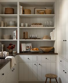 a kitchen filled with lots of white cupboards and counter top space next to a sink