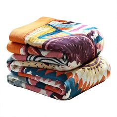 four colorful towels stacked on top of each other in different colors and patterns, all folded neatly