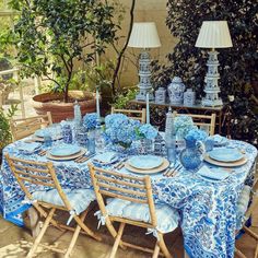 a table with blue and white plates, vases and lamps