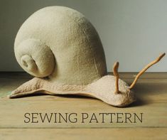 a close up of a stuffed animal snail on a wooden floor with the words sewing pattern