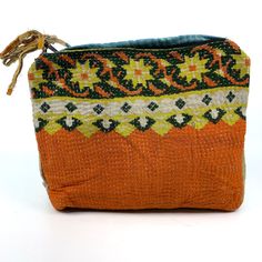 an orange and green purse with a rope hanging from it's side on a white background