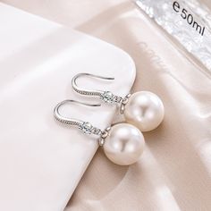 Regally divine, these pearl drop earrings are a tasteful addition to her jewelry box. Created in sterling silver, each beautiful earring showcases a beguiling 12mm white cultured pearl and shimmering white stones. With ease and elegance, these classic pearl drop earrings complete her tailored anytime attire.Width: 12 mmHeight: 30 mmThickness: 12 mmMaterial: 925 SilverPlating Color: Silver White Pearl Drop Earrings In Cubic Zirconia, Elegant Pearl Earrings With Pearl Pendant, Elegant Pearl Earrings With Pendant, White Bridal Earrings With Pearl Charm And Cubic Zirconia, Pearl White Pearl Drop Earrings With Cubic Zirconia, Elegant Pearl White Pearl Earrings For Anniversary, Diamond White Drop Pearl Earrings, Elegant White Pearl Bridal Earrings, Graceful Pearl White Earrings