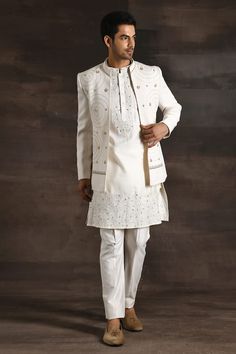 White open sherwani with all over geometric pattern, metallic trims, zari, beads and thread embroidery. Paired with floral embroidered kurta and pant. - Aza Fashions Elegant Nehru Jacket With Mirror Work For Festive Occasions, Elegant Festive Bandhgala With Mirror Work, Elegant Nehru Jacket With Mirror Work For Transitional Season, Designer Festive Bandhgala With Mirror Work, Elegant Nehru Jacket With Mirror Work For Festivals, Wedding Nehru Jacket With Mirror Work, Designer Nehru Jacket With Mirror Work For Eid, Designer Nehru Jacket With Mirror Work For Weddings, Designer Nehru Jacket With Mirror Work For Festive Season