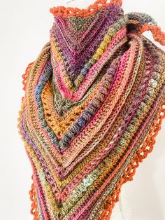 a multicolored crocheted shawl on a mannequin