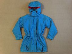 "1990's, drawstring waist, hooded, parka, in bright blue and red, by Columbia, Women's size Small. Shell and lining are 100% nylon. Insulation is 65% olefin, 35% polyester. Made in Korea. Zip front, with velcro. Drawstring at inside of waist, with plastic squeeze pulls. One inside, zipper pocket. Front, zipper pockets, and breast, zipper pocket. Velcro tab cuffs. Snap on/off, hood. There is a mark on the front of one shoulder, some light dinge at the edges, a faint mark on the bottom of the fron Polyester Pants, Hooded Parka, Double Breasted Jacket, Bright Blue, Drawstring Waist, Double Breasted, Parka, Columbia, One Shoulder