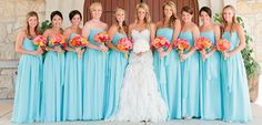 a group of women standing next to each other in front of a door holding bouquets