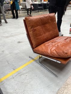 a brown leather chair sitting on top of a metal frame