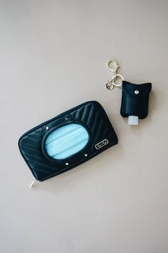 a blue case with a key chain attached to it and a black bag on the side