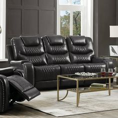 a living room filled with black leather furniture