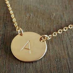 My Kiersten gold initial necklace is personalized with your choice of letter, hand stamped onto the charm creating a lovely custom necklace. This hand stamped 5/8" charm (size of US dime) is hand stamped with your choice of letter (or word, design, number) using traditional tools.  I polish and hang the piece from a gold-filled cable chain (choose 16", 18" or 20" at checkout).  Gold-filled metal contains a double layer (front/back) of gold that is much, much thicker than gold-plated metal.  Gold Gold Initial Necklace Hand Stamped For Gift, Gold Hand Stamped Initial Necklace Gift, Gold Hand Stamped Initial Necklace For Gift, Gold Sterling Silver Hand Stamped Initial Necklace, Hand Stamped Initial Necklace In Minimalist Style, Dainty Hand Stamped Initial Necklace For Personalized Gift, Simple Custom Name Gold Jewelry, Hand Stamped Initial Necklace For Personalized Gift, Minimalist Hand Stamped Initial Necklace As Personalized Gift