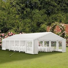 a large white tent with tables and chairs set up in the middle of a field