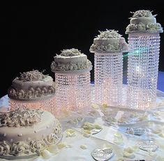 a table topped with lots of cakes covered in frosting and icing on top of a white table cloth