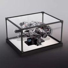 a toy car in a glass case on top of a black table with white background