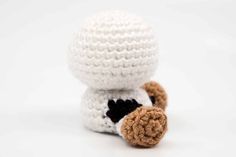 a small crocheted stuffed animal with a black and white shirt on it's chest