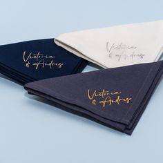 three folded napkins with writing on them sitting next to each other in front of a blue background