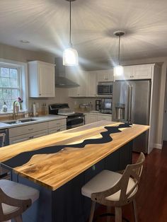 a kitchen with an island made out of wood and white cabinets is pictured in this image