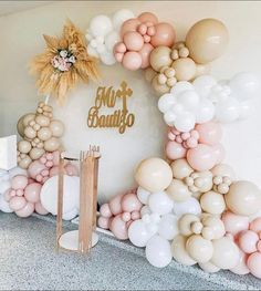 the balloon arch is decorated with white, pink and gold balloons