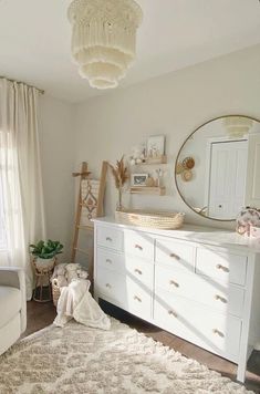 a baby's room with white furniture and neutral decor, including a crib