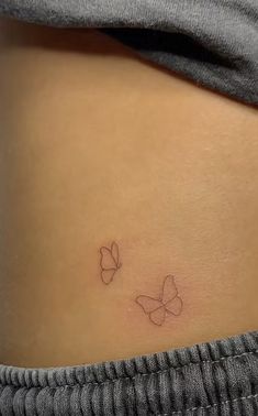 a woman's stomach with two small butterflies on the side, and one smaller butterfly at the top