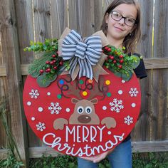 "The holiday season is in the air. This personalized Christmas door sign makes a perfect gift for weddings, housewarmings, anniversaries, etc! How it's made: This door sign is made of two layers. I cut the backing from 1/2\" birch plywood, the words and teams are cut from 1/4\" plywood.   Each piece is then hand painted, and glued together. Sign sizes are approximately 15\", 18\", 20\", and 22. Exterior lacquer is applied to the finished product to help extend the life of your door hanger. The b Christmas Wood Round Signs, Christmas Wood Door Hangers, Reindeer Door Hanger, Christmas Front Door Decor, Christmas Door Sign, Christmas Tree Door, Reindeer Decor, Hanger Christmas, Tree Door