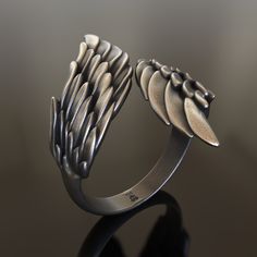 Introducing our enchanting handcrafted 925 Sterling Silver Wings Ring, a captivating accessory that symbolizes freedom, spirituality, and the ethereal world of angels. This unique ring features an intricate design of delicate wings, crafted from high-quality, solid 925 sterling silver to ensure durability and longevity. Our Wings Ring is a unisex accessory, making it a perfect choice for both men and women who appreciate the allure of angelic symbols and the idea of soaring free. Its detailed de Promise Sterling Silver Jewelry With Oxidized Finish, Symbolic Sterling Silver Jewelry With Unique Design, Sterling Silver Winged Rings In Silver, Spiritual Winged Sterling Silver Jewelry, Hand-cast Sterling Silver Promise Jewelry, Artistic Sterling Silver Jewelry With Unique Design, Angelic Symbols, Wings Ring, Viking Ring