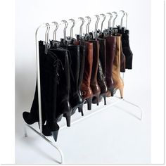 a rack with several pairs of boots hanging from it's sides and two hooks on each side