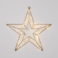 a lighted star ornament hanging on a wall with lights in the shape of a star