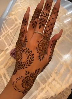 a woman's hand is decorated with hennap and flowers on it,