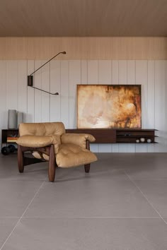 a chair and ottoman in a room with wood paneling on the wall behind it