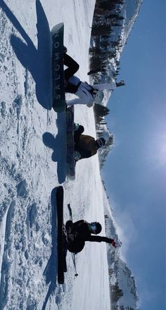 three people standing in the snow with their skis